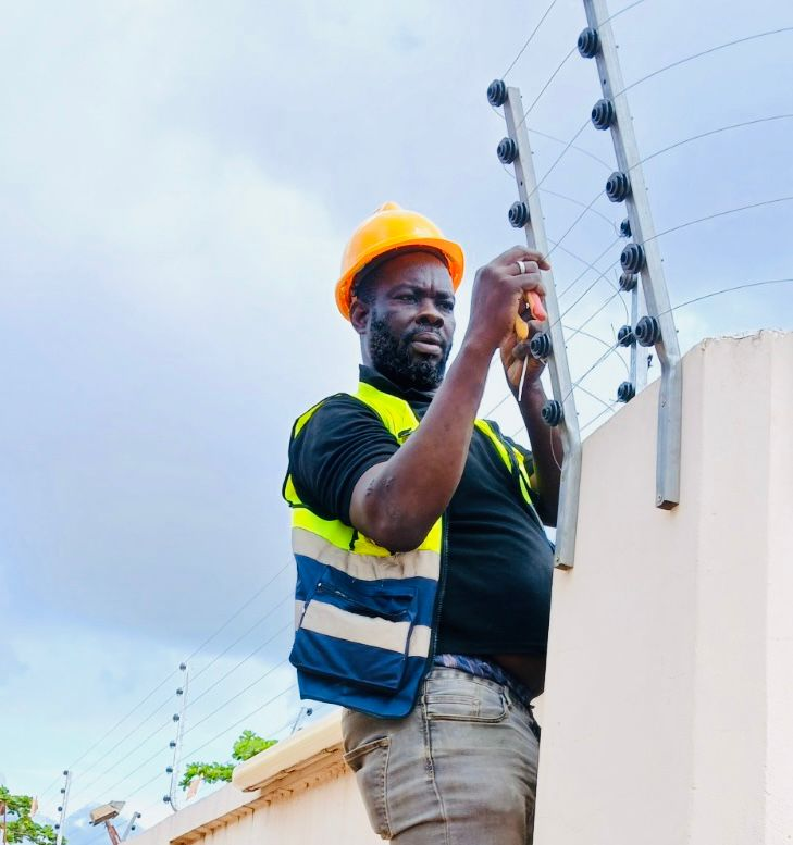 GESINGO technician fitting electric-fence wiring on a perimeter wall